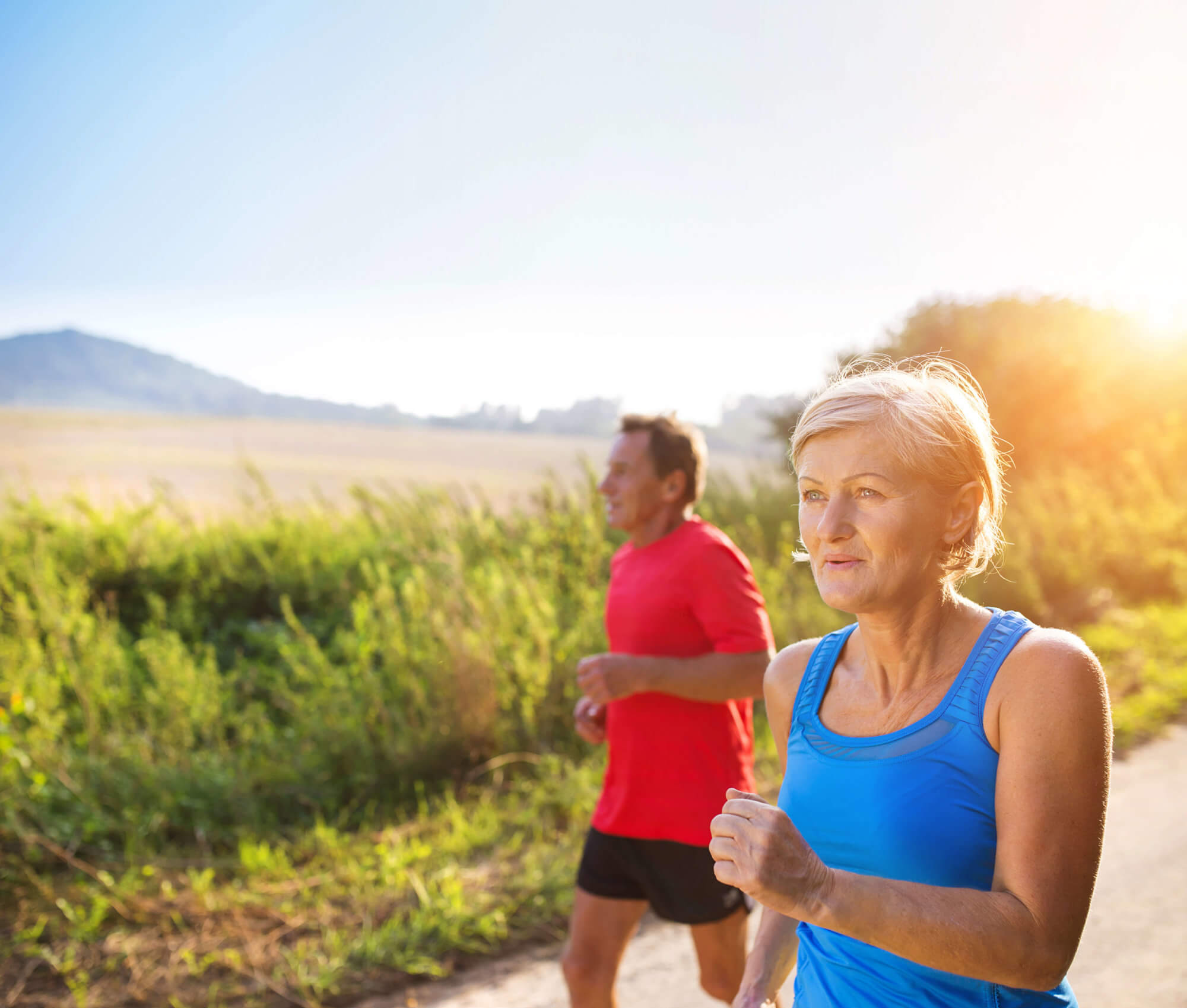 older couple jogging outside in warm weather